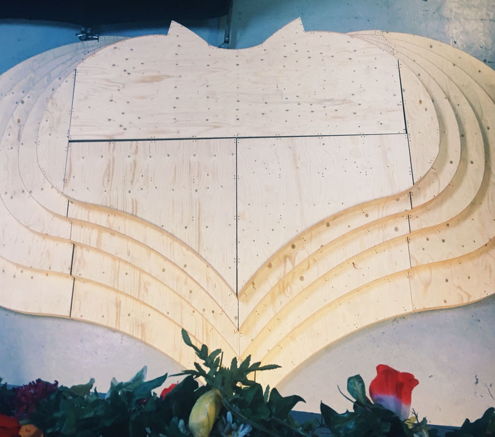 A large layered plywood set piece, cut into curved shapes, built flat in the workshop.