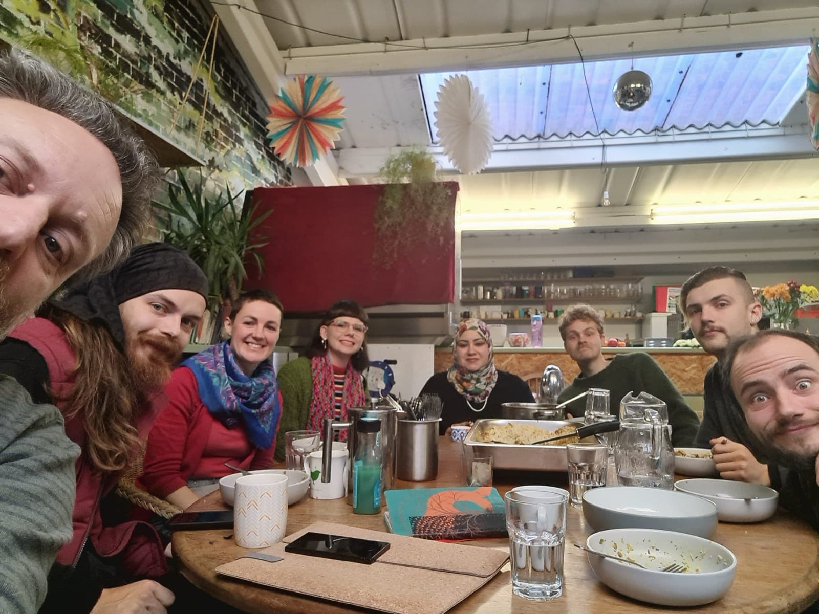 The team gathered round the cafe table for a shared meal, photographed from one end.