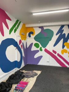 The communal parts of the Open Source Arts studio building are decorated with bold and colourful murals.