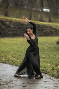 Shivani performing Kathak dance in a path in a field