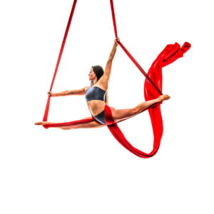 Jess performing an aerial split pose using red silks against a white background.